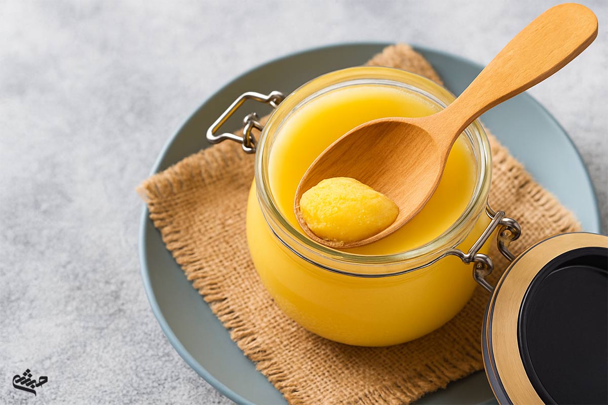 close-up of ghee in jar with wooden spoon